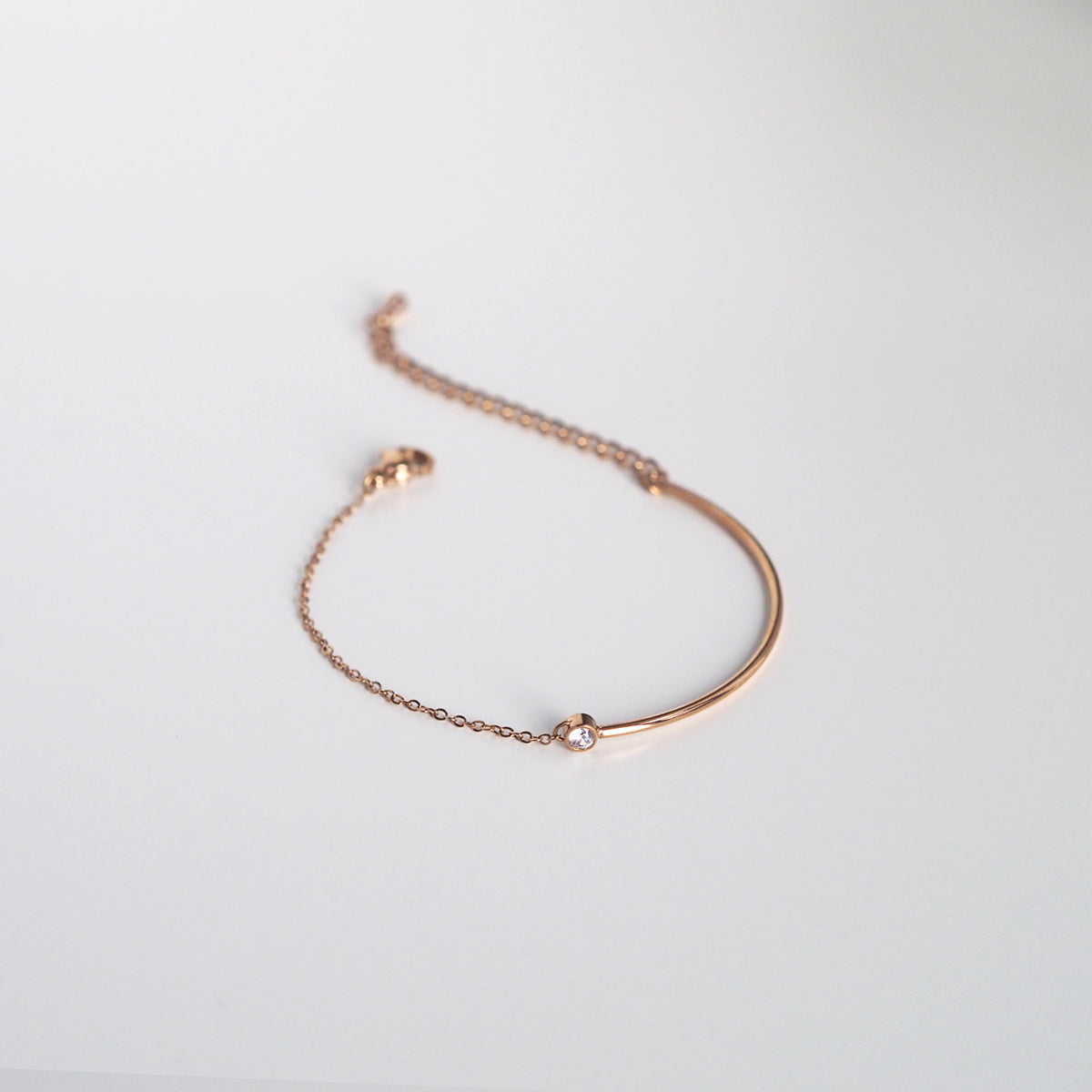 Minimalist rose gold bracelet with a glossy finish and subtle luxury appeal.