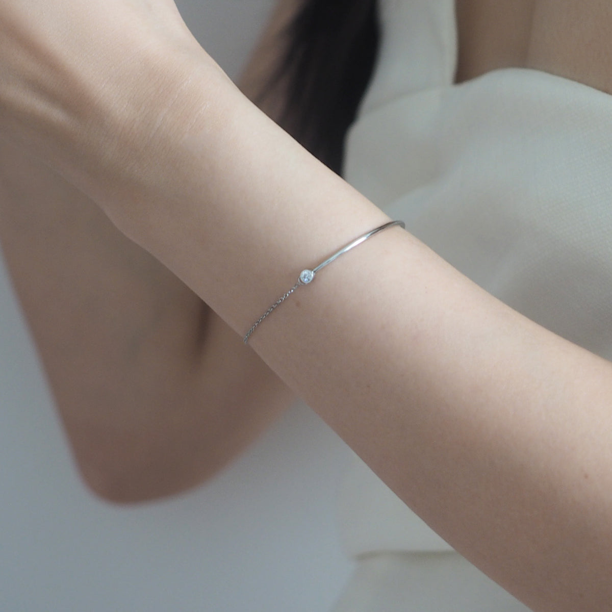 Elegant gold-plated Vera Zirconia Bracelet with a shimmering diamond, worn by a stylish woman.