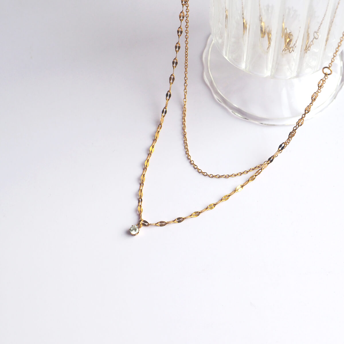 An elegant gold chain necklace with a dazzling crystal pendant, showcasing a blend of style and sophistication.