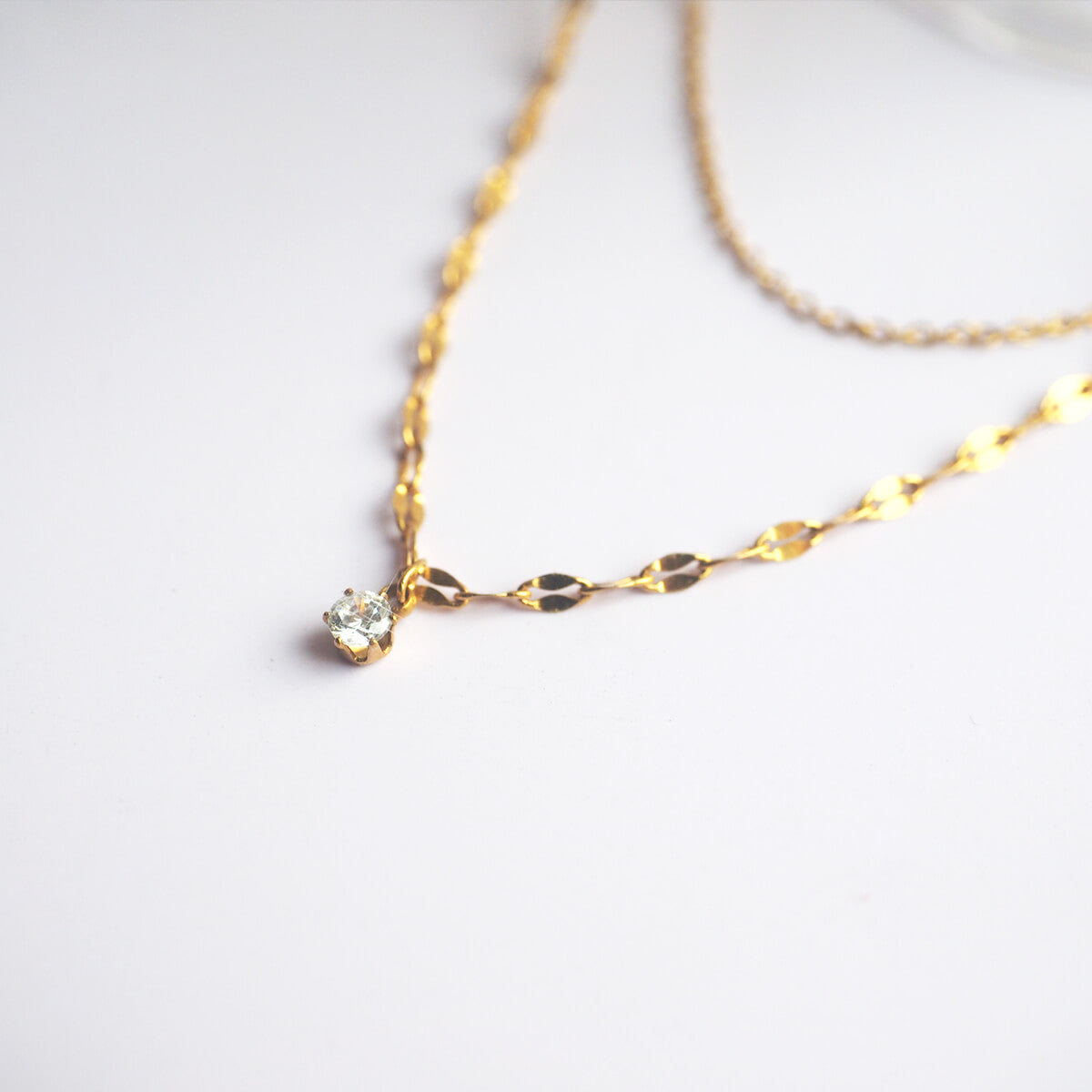 An elegant gold necklace with a crystal centerpiece, radiating sophistication and timeless beauty.
