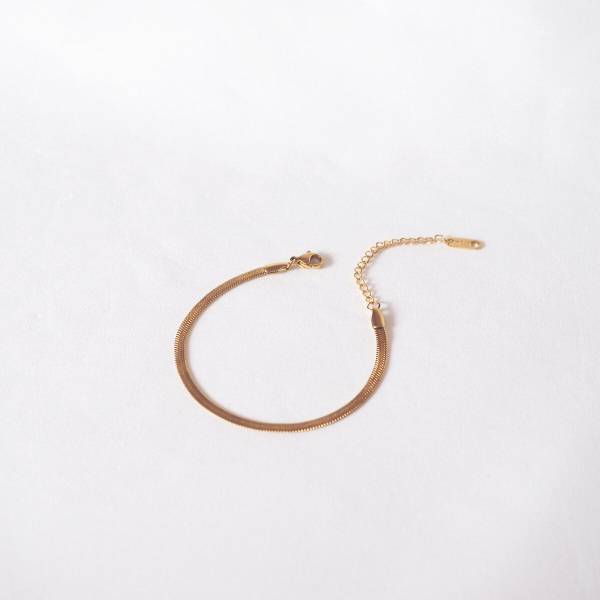 Chic gold bracelet adorned with a subtle chain, offering a stylish twist to your everyday accessories.