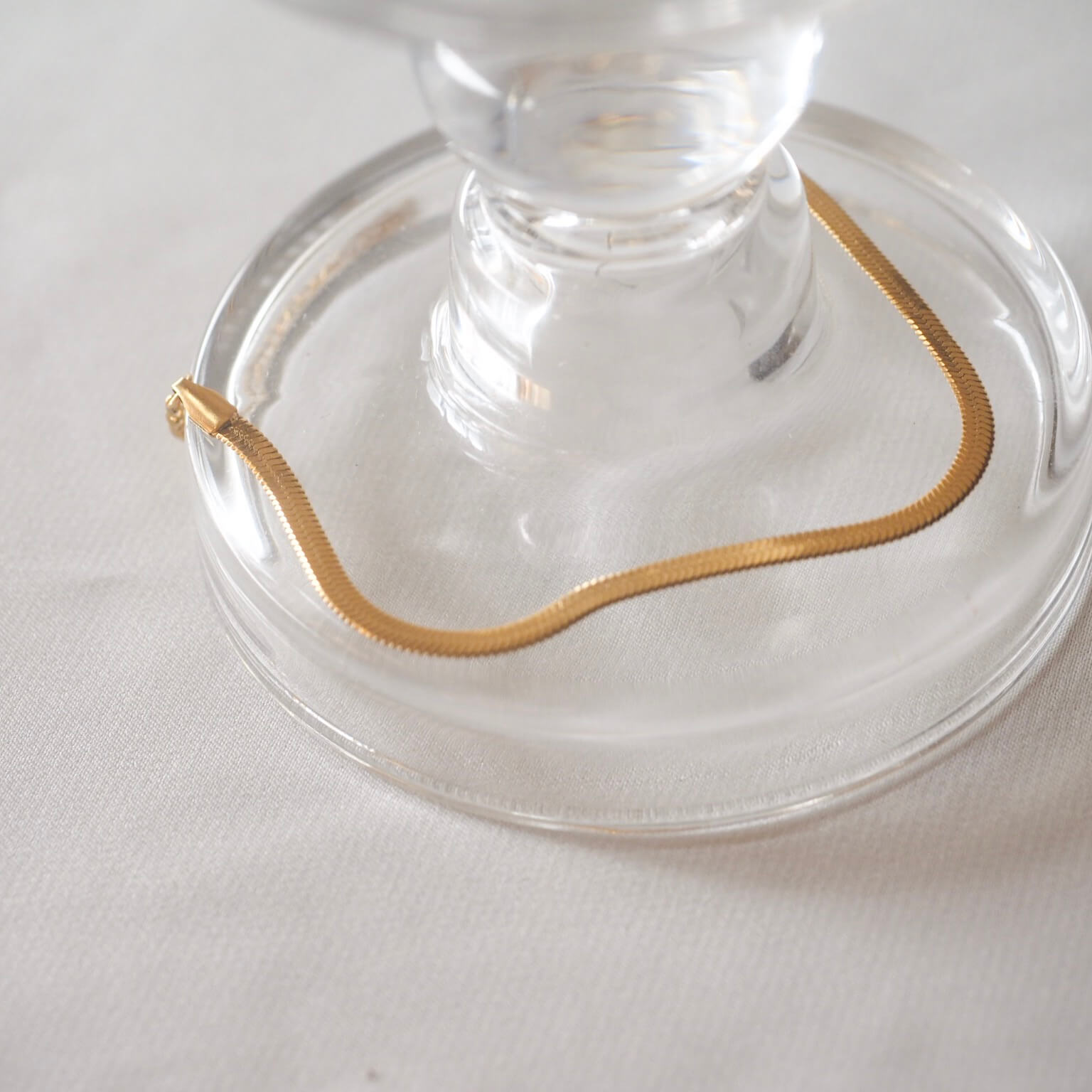 A glass vase topped with a gold bracelet, showcasing elegance and simplicity in design.