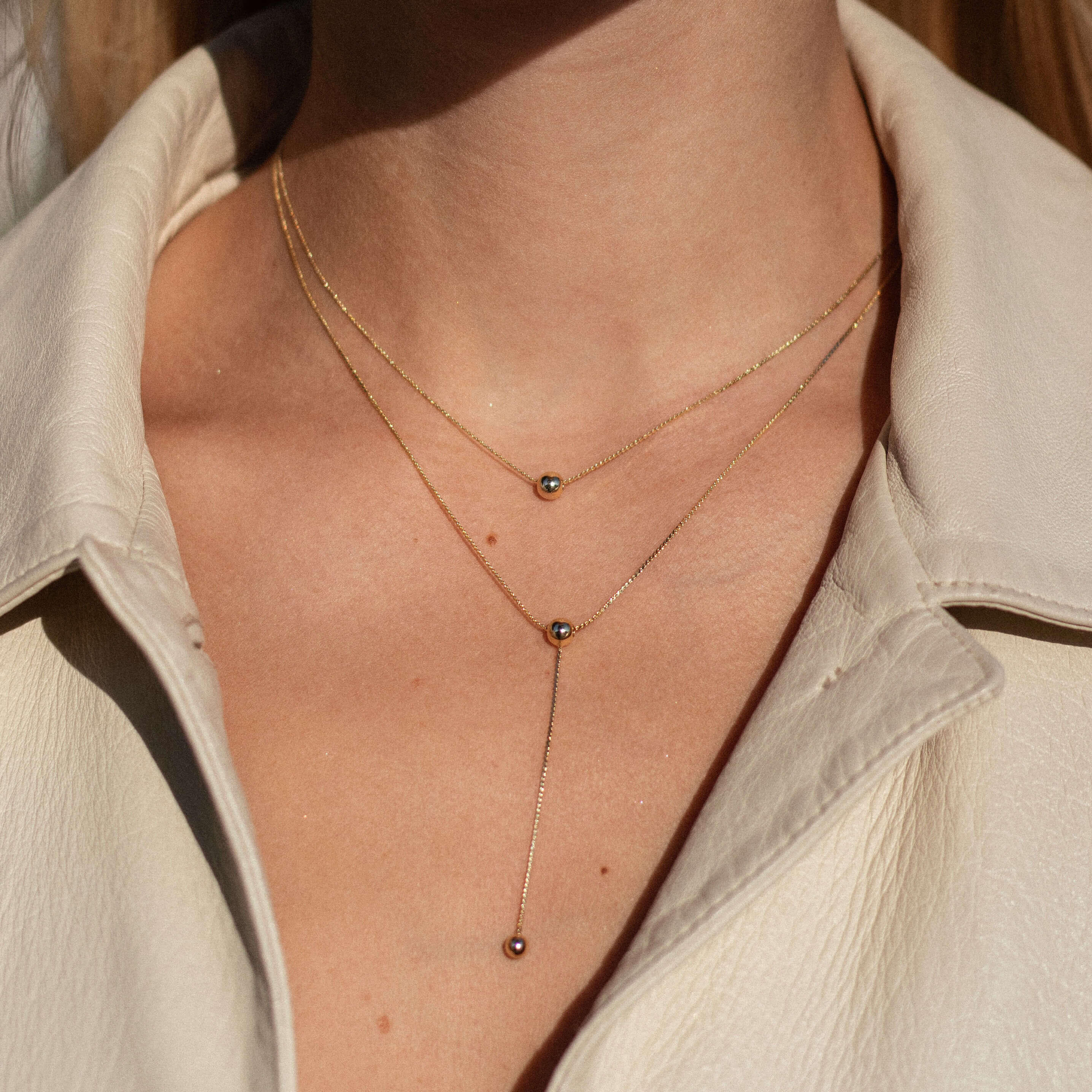 Stunning gold necklace adorned with two small diamonds, designed with a double-layer chain for a chic and adjustable look.