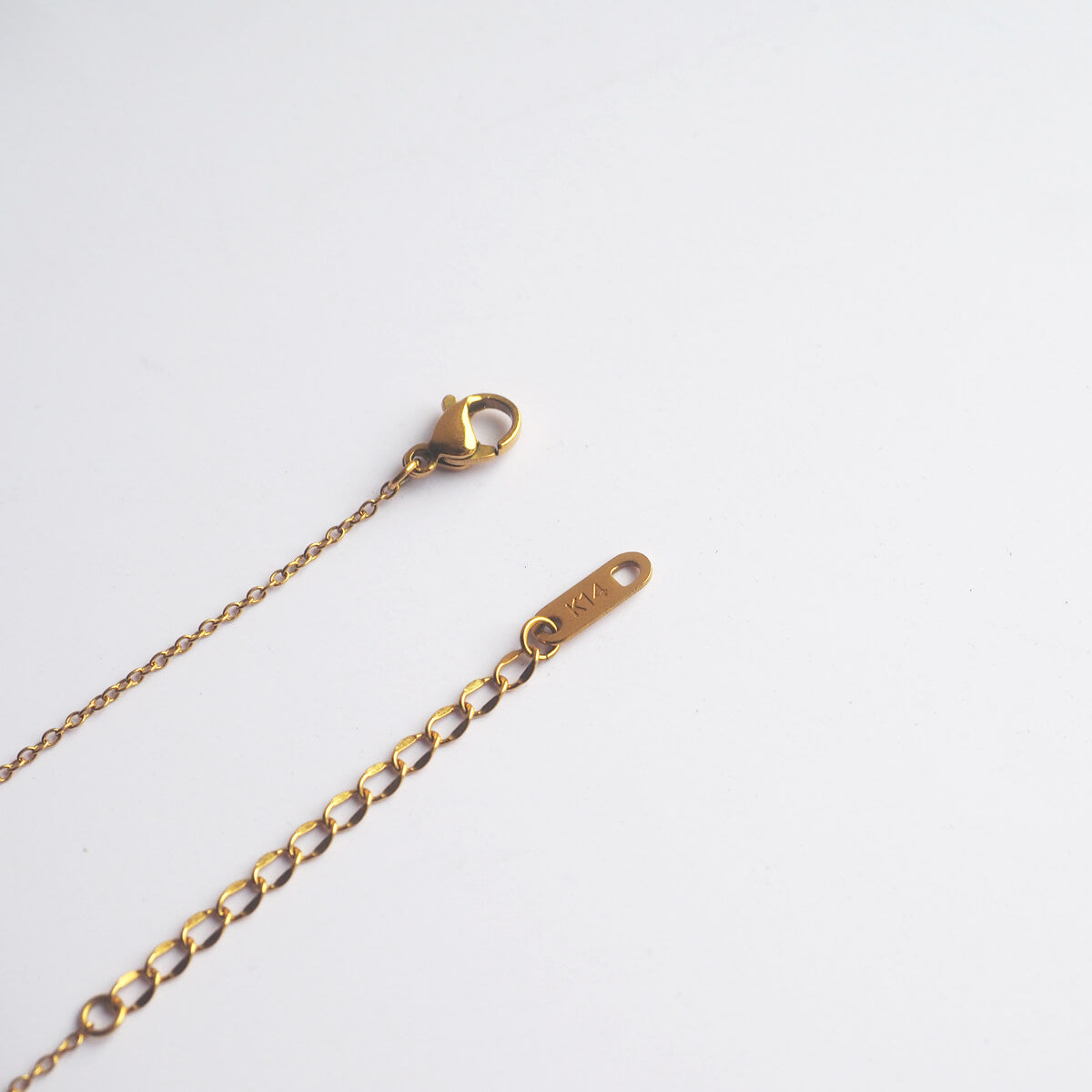 An image of a gold chain with a delicate clasp, emphasizing its refined style and gleaming surface.