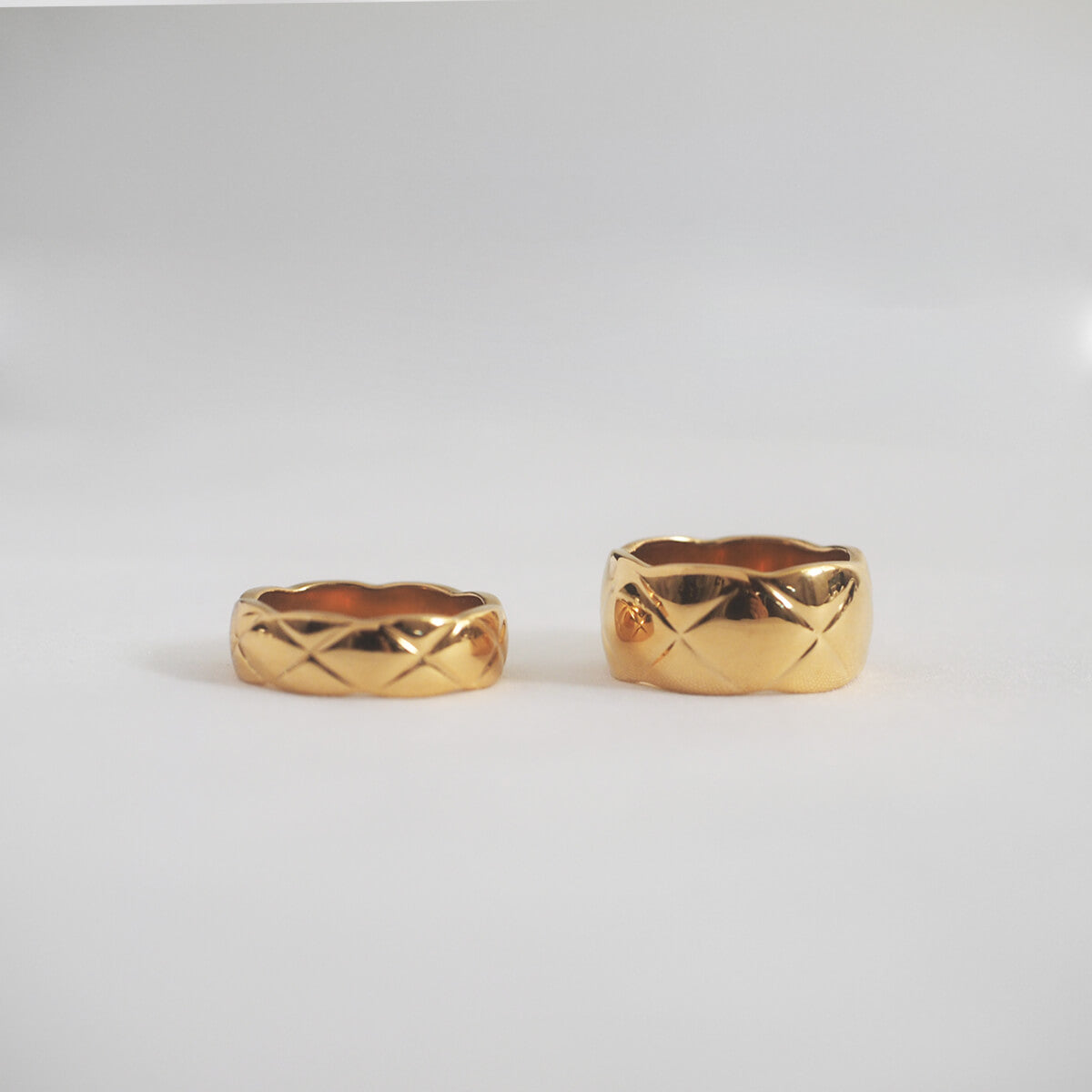A pair of gold rings featuring dazzling diamonds and a distinctive "X" motif, perfect for adding elegance to any outfit.