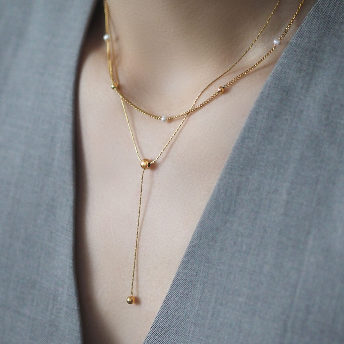 Chic gold necklace adorned with two pearls on a minimalist double chain, a perfect accessory for a stylish finish.