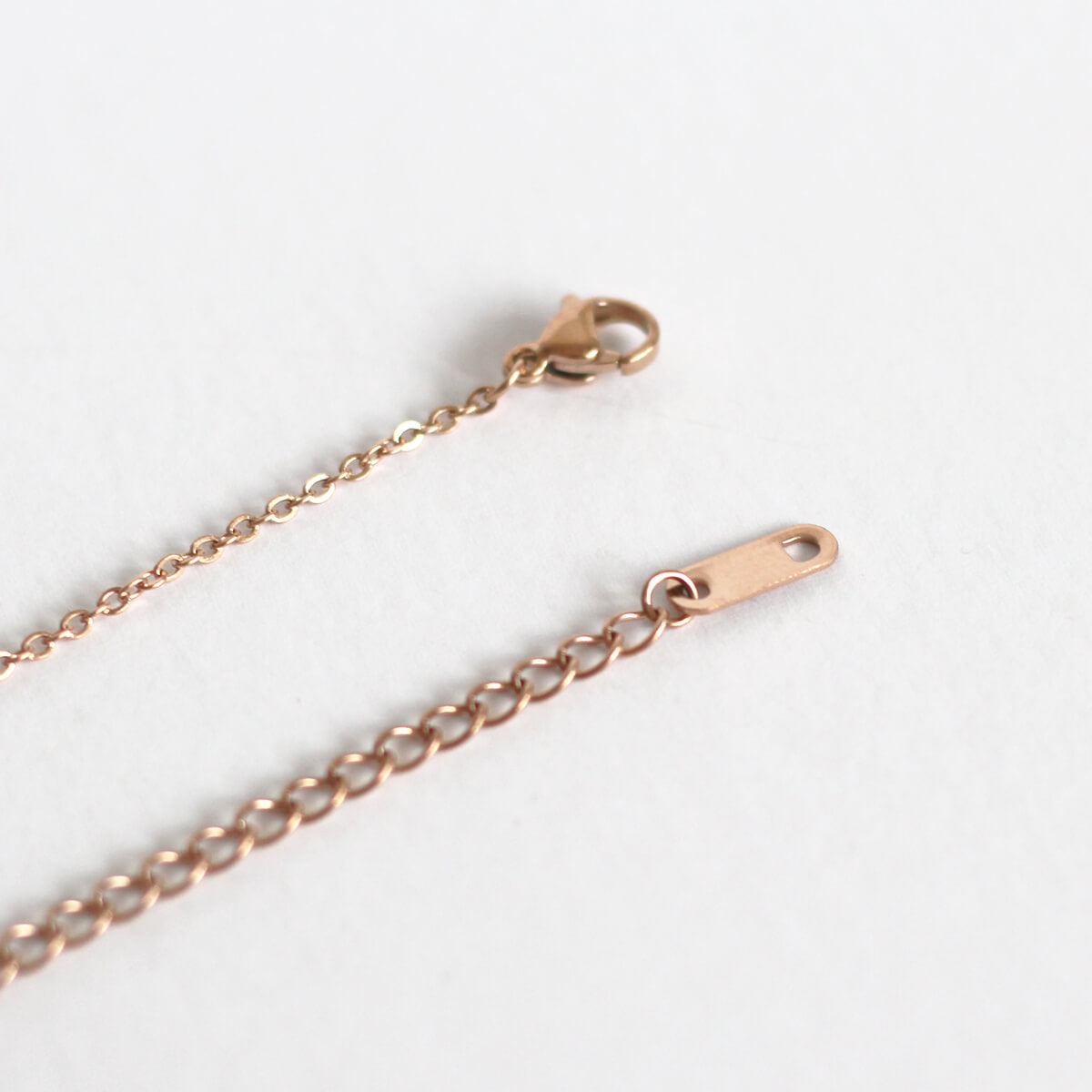 Detailed close-up of a gold chain showcasing a small clasp, emphasizing the chain's luxurious texture and craftsmanship.