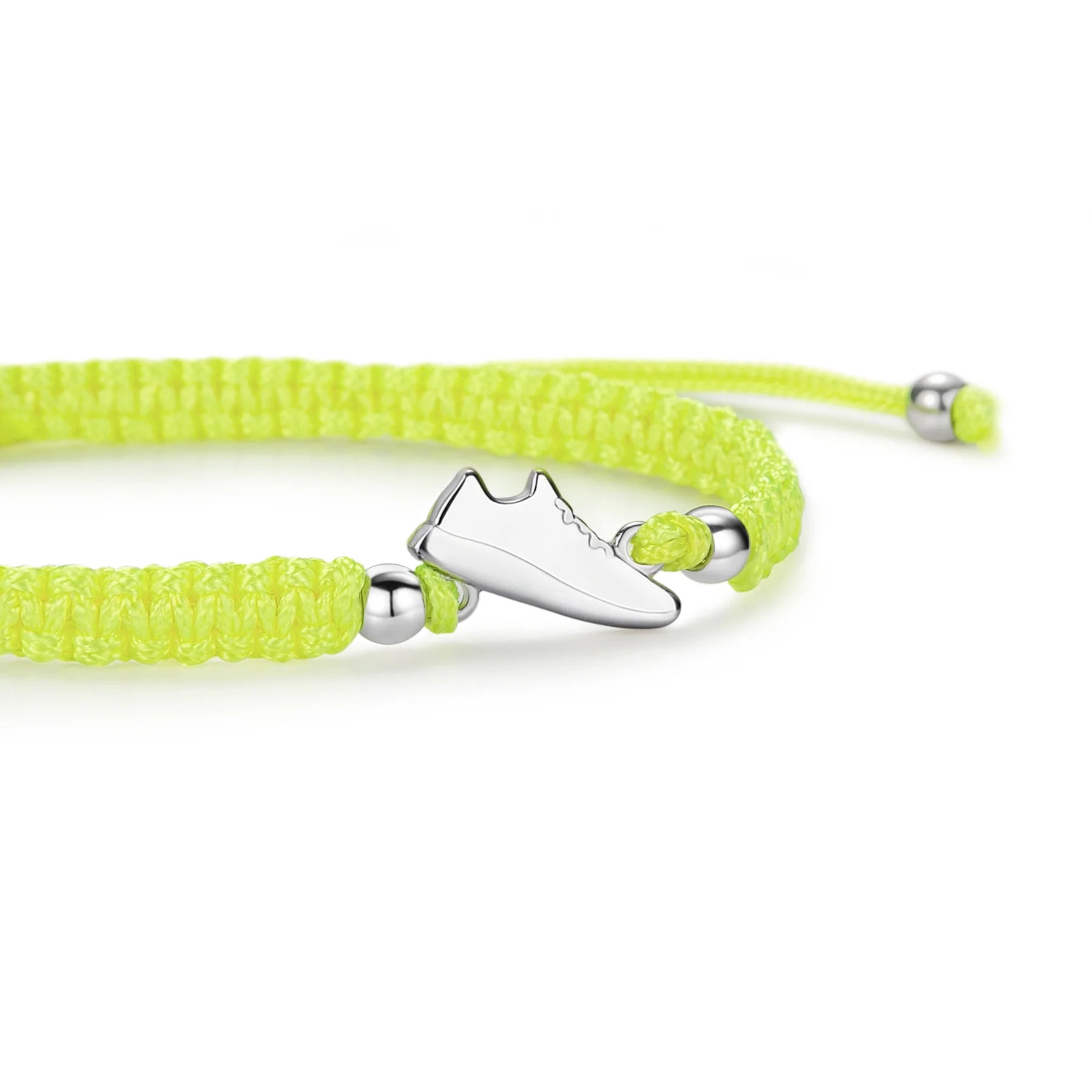 Close-up view of the silver sneaker charm on a neon yellow braided bracelet.