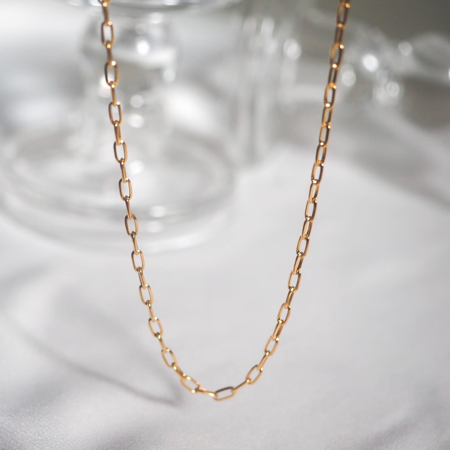 A stylish gold chain necklace showcasing small links, perfect for adding a touch of elegance to any outfit.