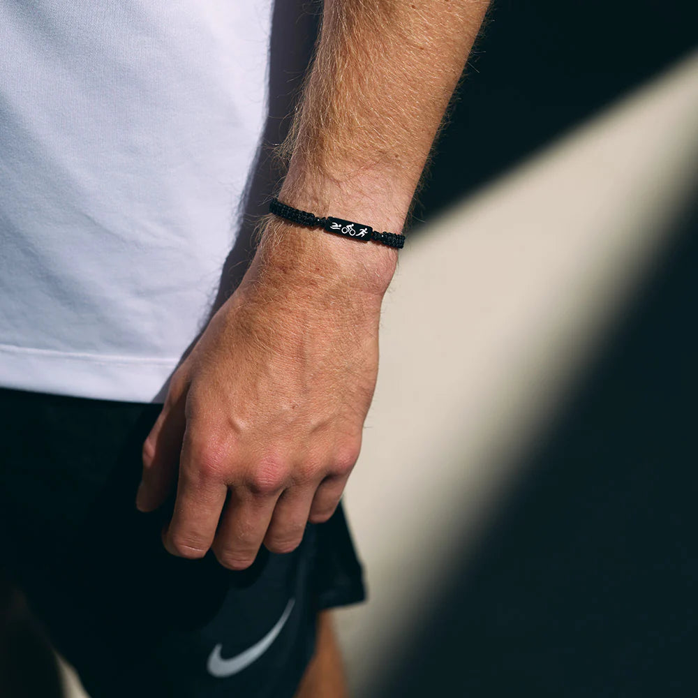 Person wearing a black bracelet on a blurred background