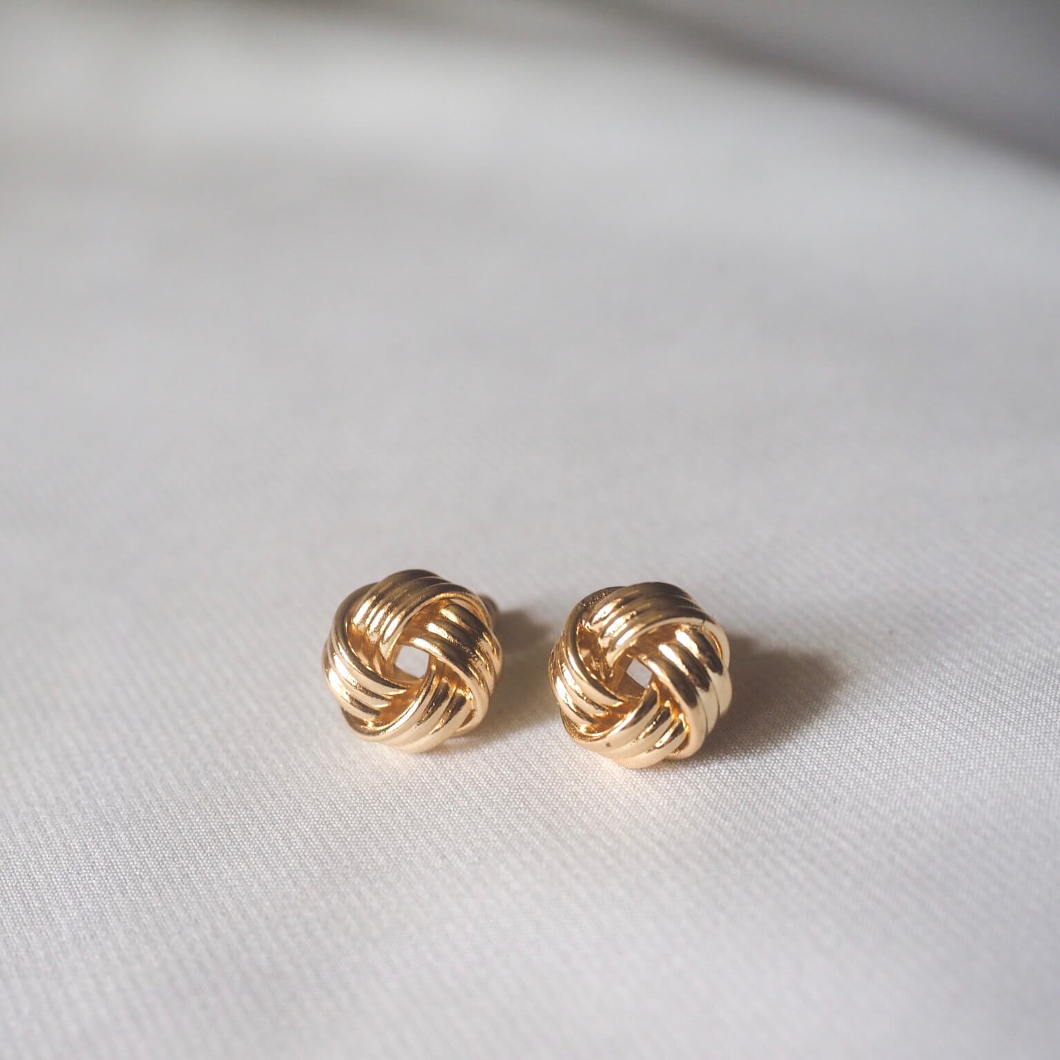 Elegant gold knot stud earrings, showcasing a timeless design perfect for any occasion.