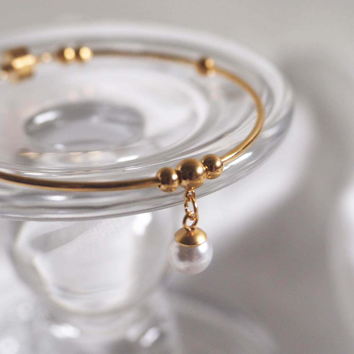 Stunning gold bracelet adorned with a beautiful pearl and a chic gold bead, adding a touch of sophistication.