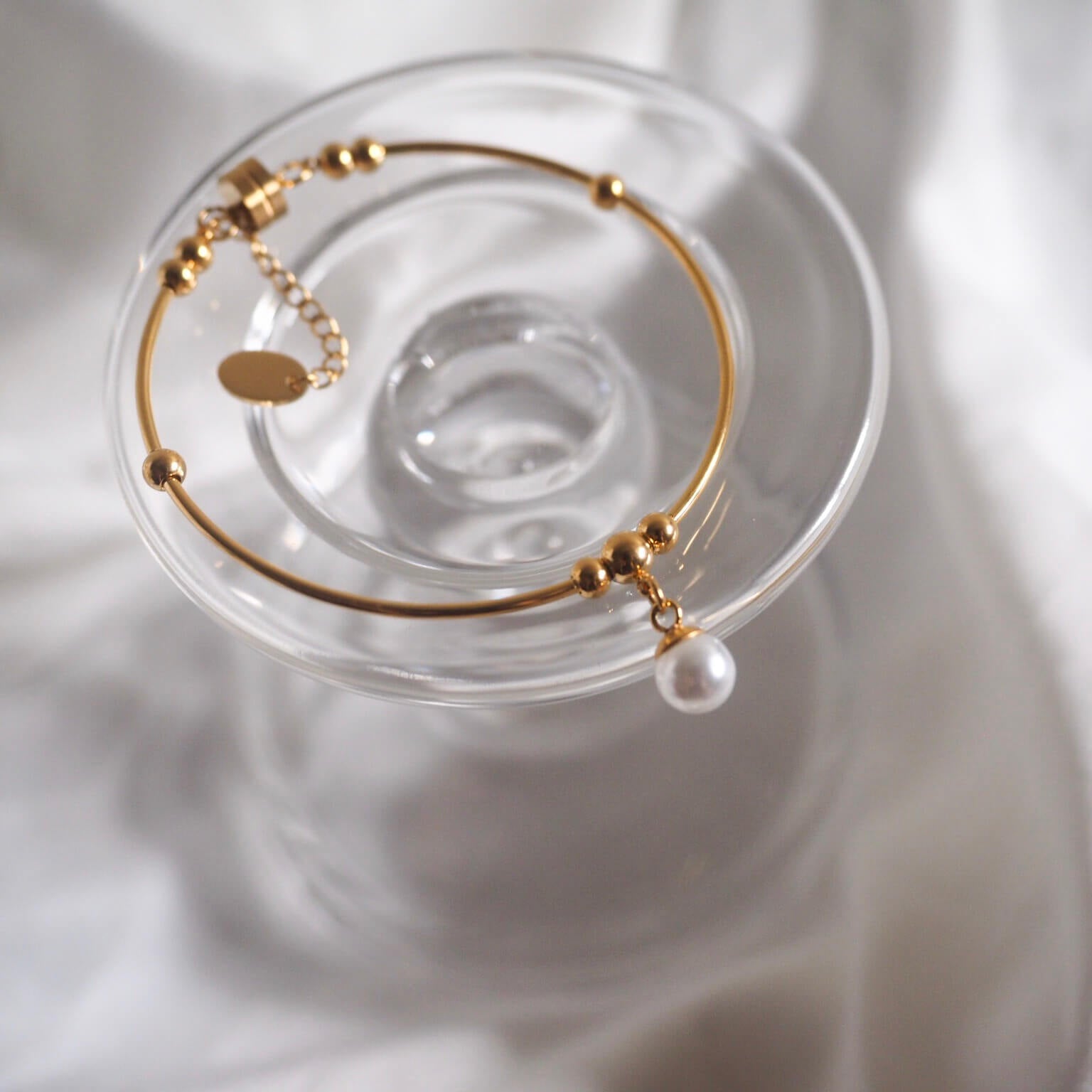 Chic gold bracelet showcasing a radiant pearl and a stylish gold charm, a must-have accessory for every jewelry lover.