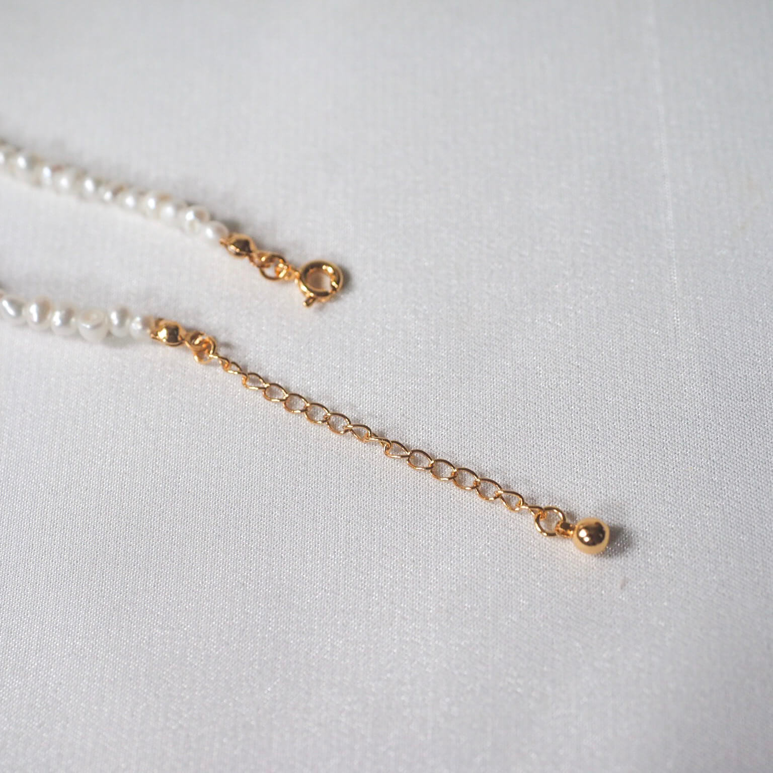 A delicate white pearl necklace, perfect for a minimalistic and elegant look for any occasion.