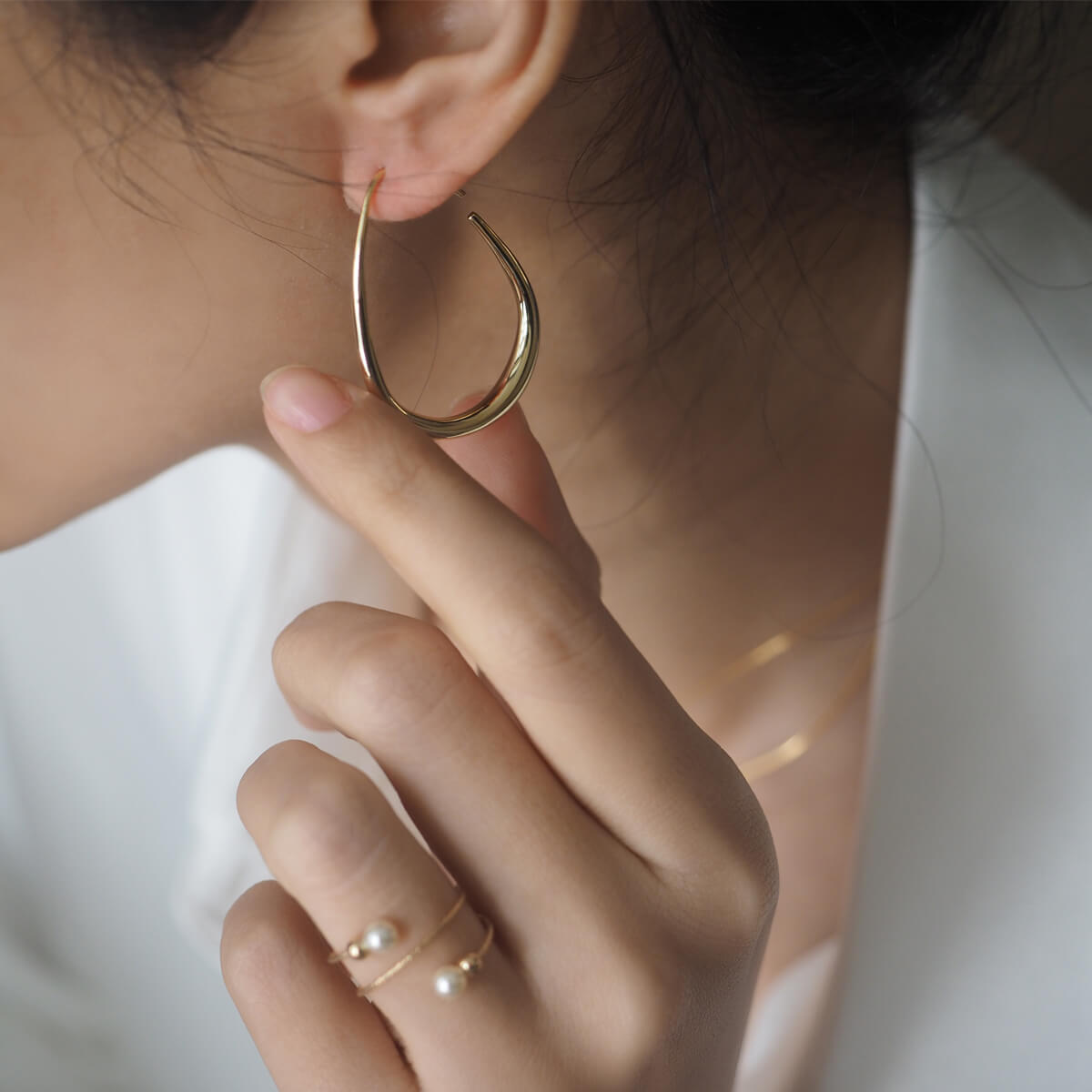 A woman adorned with a beautiful gold hoop earring, radiating confidence and style.