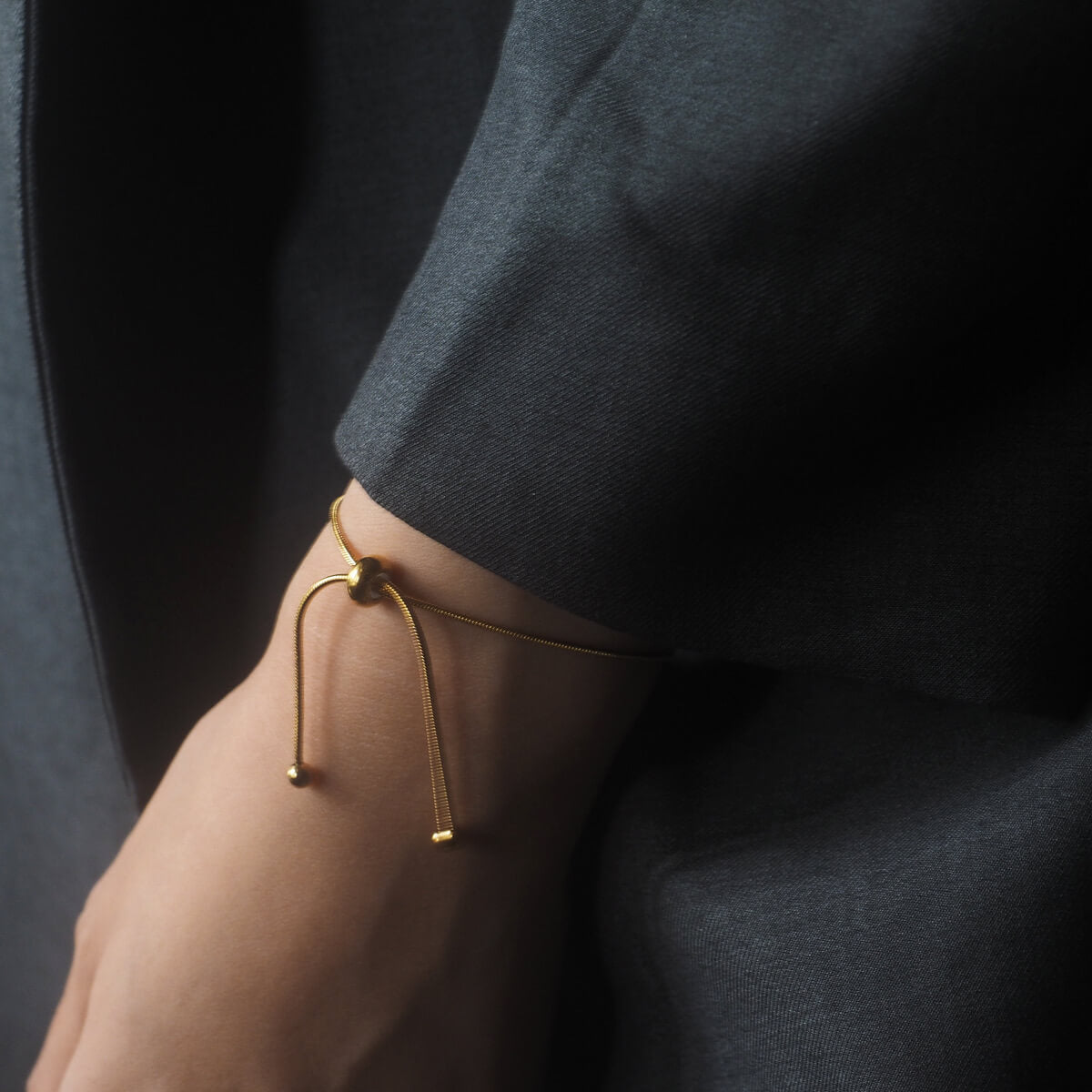 Close-up of a woman's wrist adorned with a beautiful gold bracelet, adding a touch of elegance to her look.