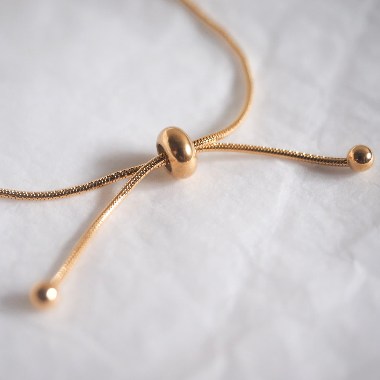 Stylish rose gold drawstring bracelet showcasing a gold-plated small ball, perfect for adding a touch of elegance.