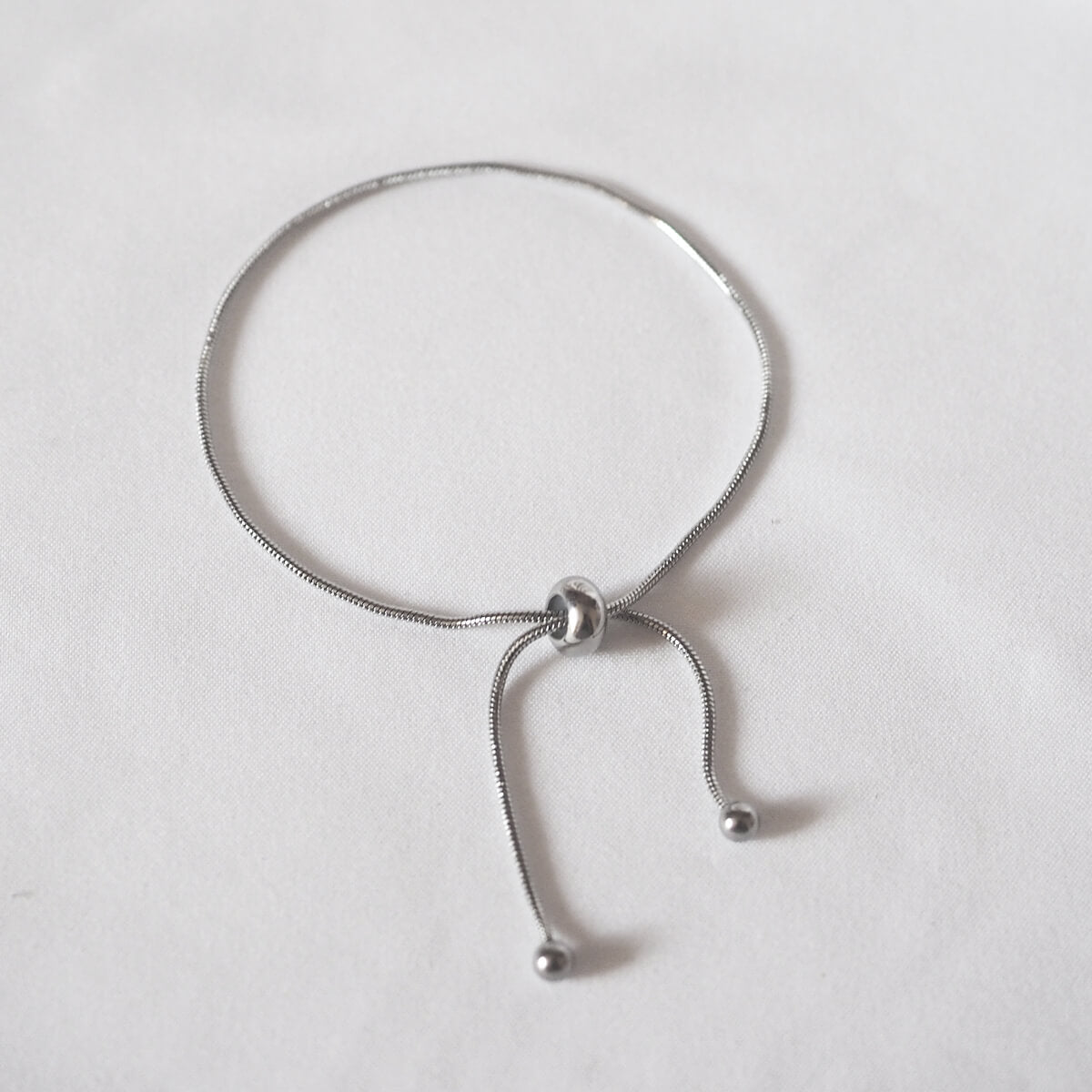 A chic silver bracelet with a distinctive knot detail, perfect for adding a touch of sophistication to any outfit.