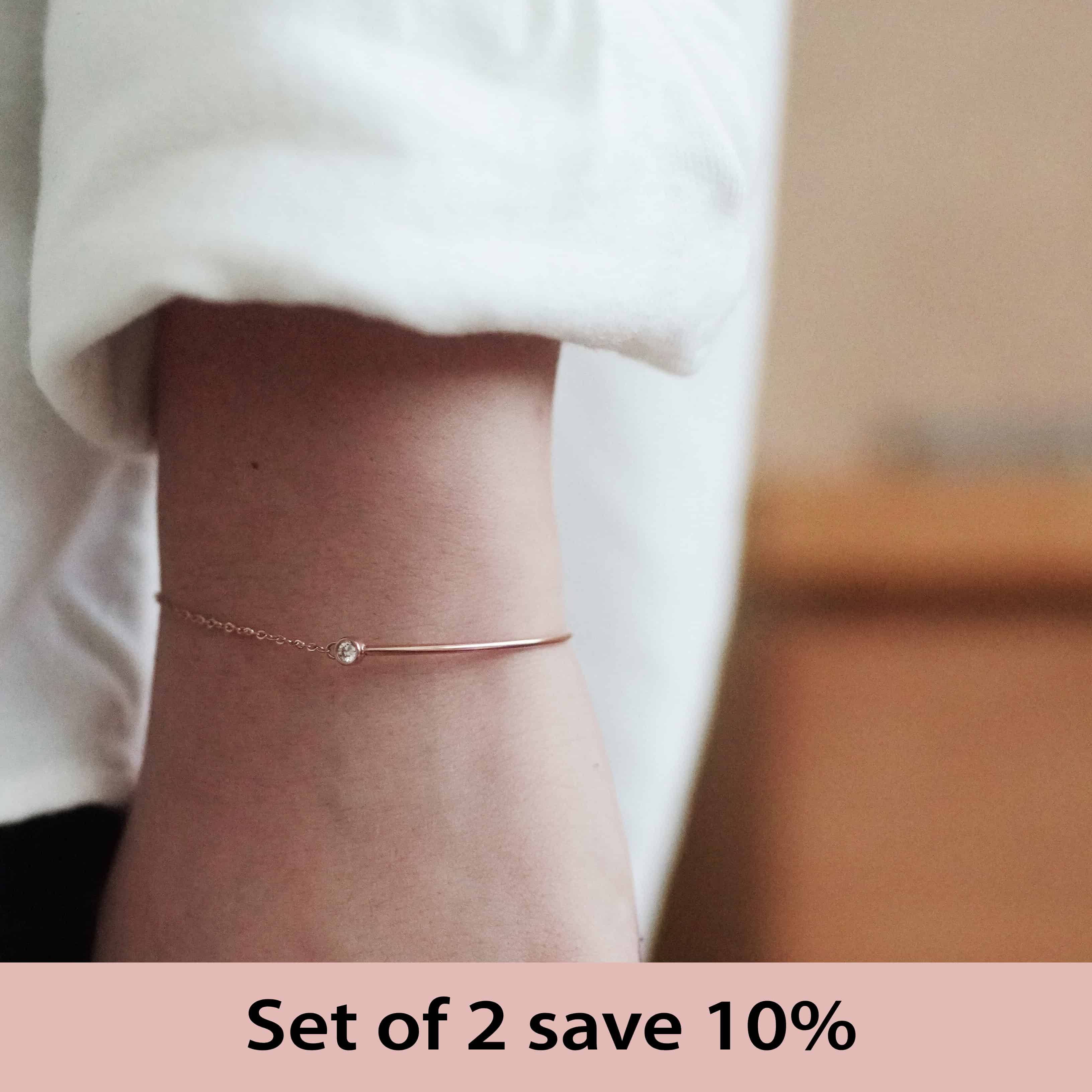 Woman wearing the Vera Zirconia Bracelet with a sparkling diamond on a sleek gold-plated design.