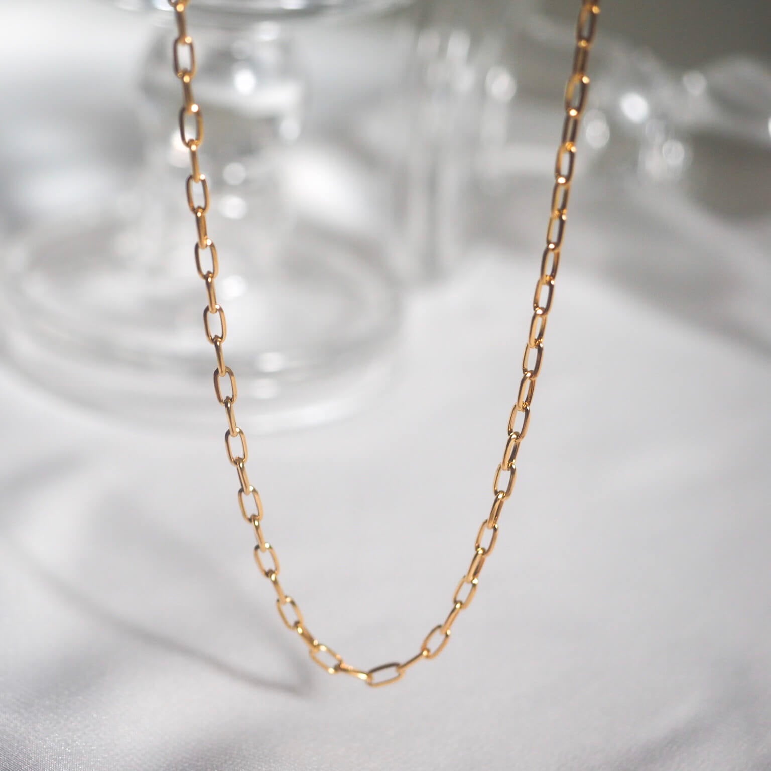 A stylish gold chain necklace showcasing small links, perfect for adding a touch of elegance to any outfit.