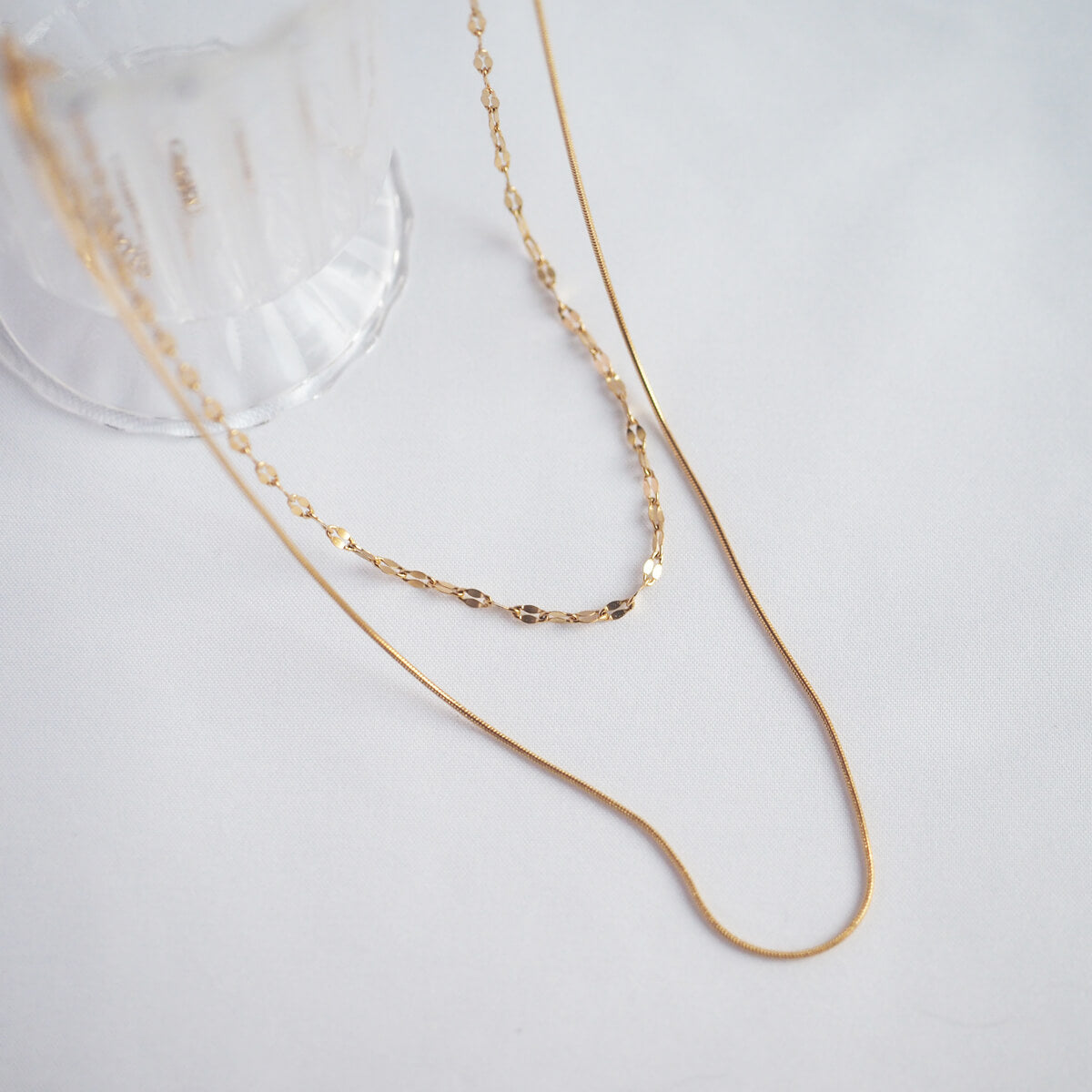 Chic gold chain necklace showcasing a clear glass pendant, a timeless accessory that enhances any look with elegance.