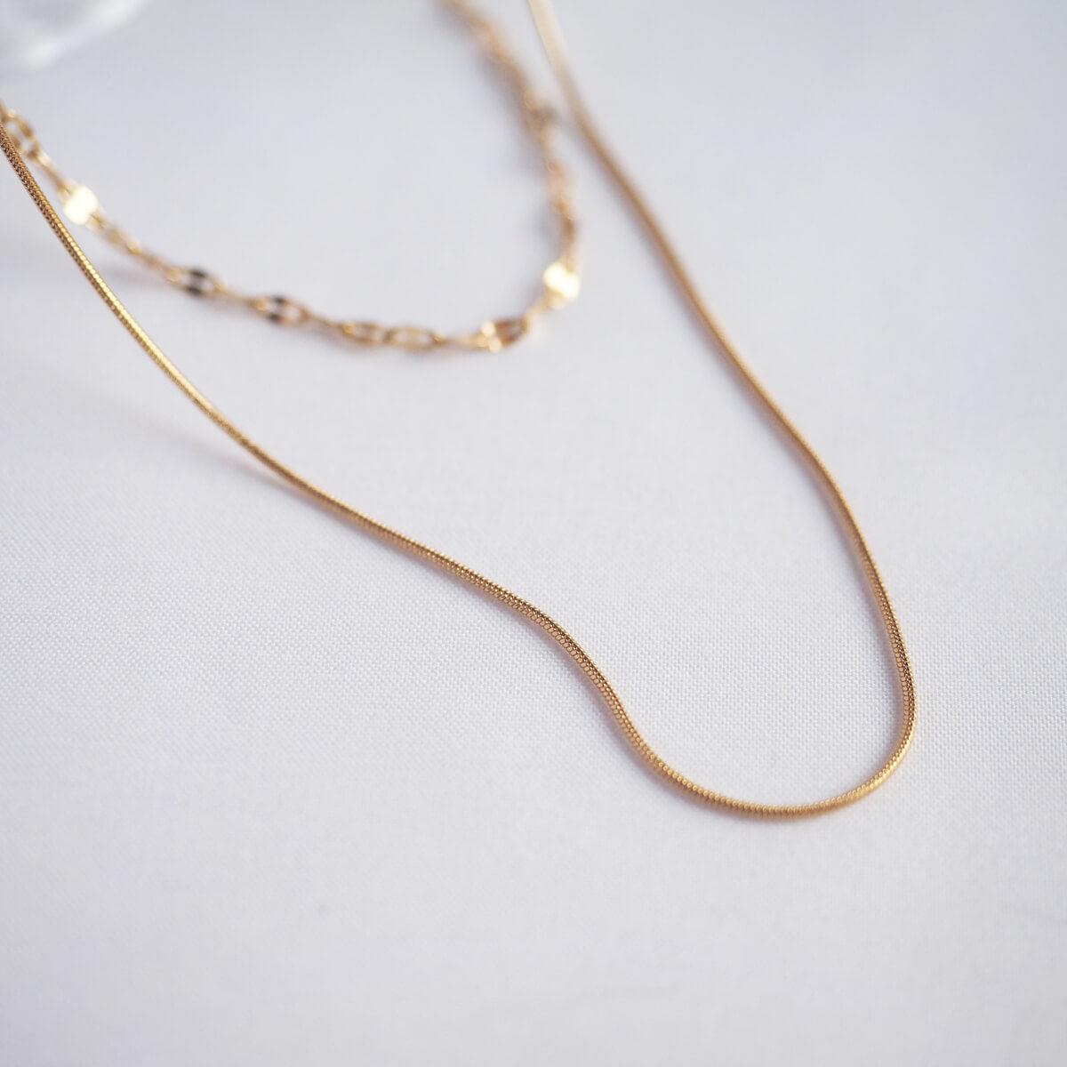 A stylish gold chain necklace adorned with a petite chain, showcasing a blend of sophistication and simplicity.