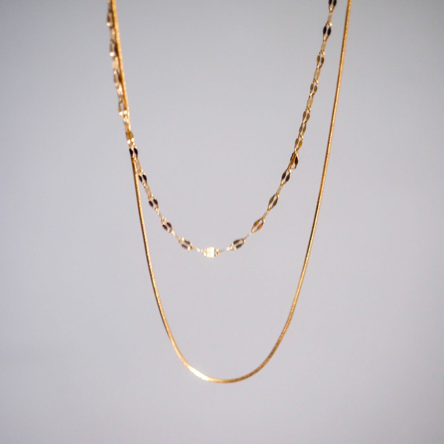 A stylish gold chain necklace with two distinct links, highlighting its luxurious appearance and intricate craftsmanship.